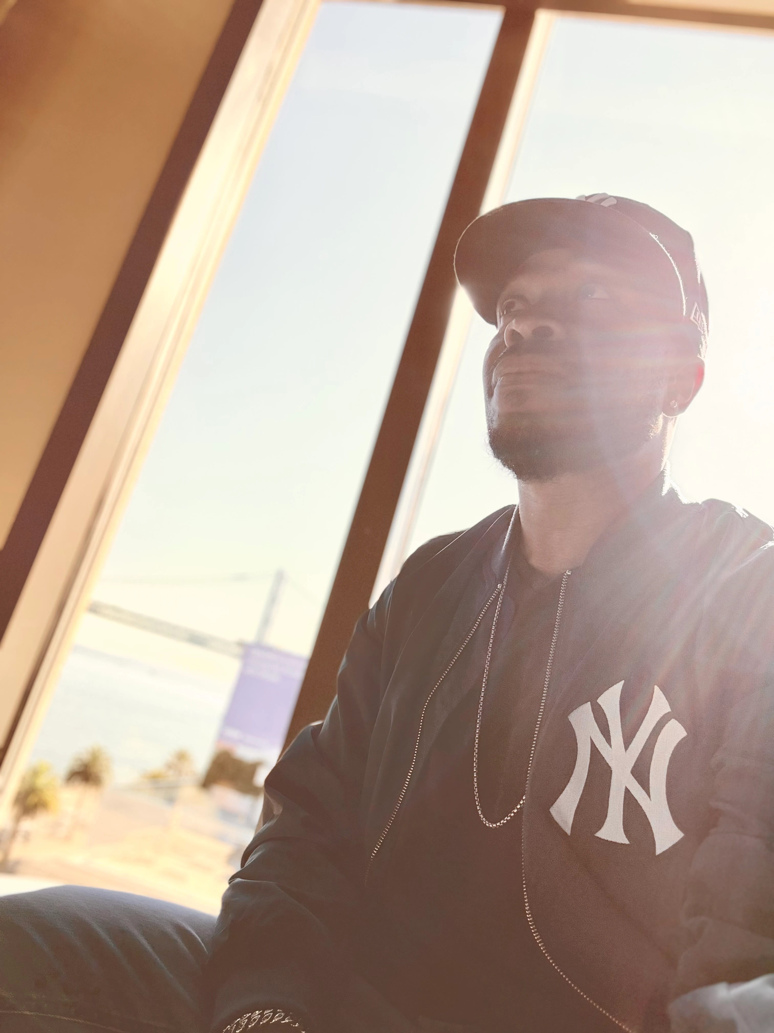 Jason sitting beside sunlit windows.
